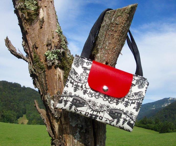 Handtasche mit Scherenschnitt-Motiv und roter Klappe