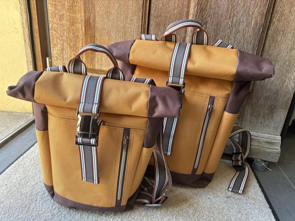 Zwei Rolltop-Rucksäcke in Ocker und Braun